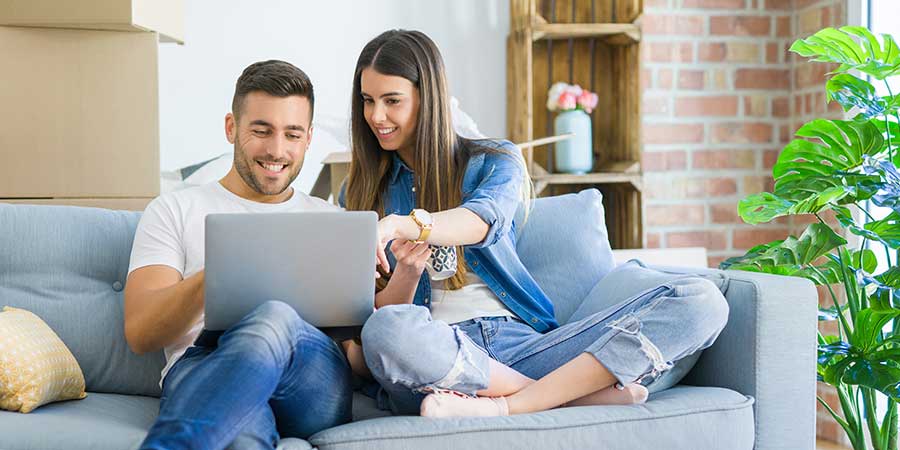 Millennial couple sitting on couch